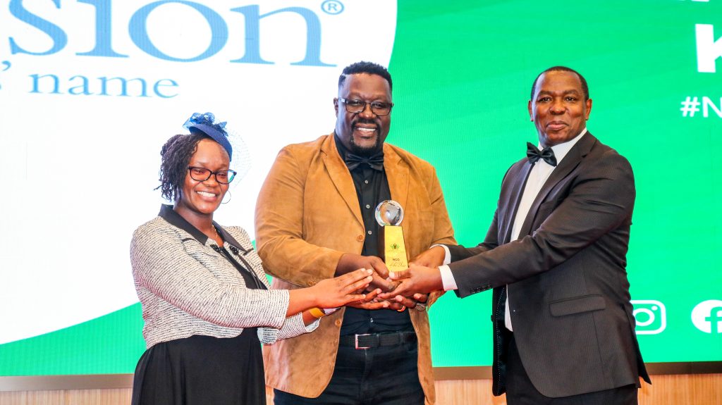 Hon. Nderitu Mureithi hands over the NGO of the year award to Compassion International.